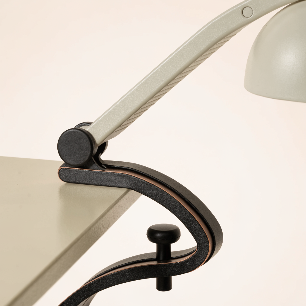 Lampe à pince fixée au bord d'un plateau de bureau, mécanisme visible