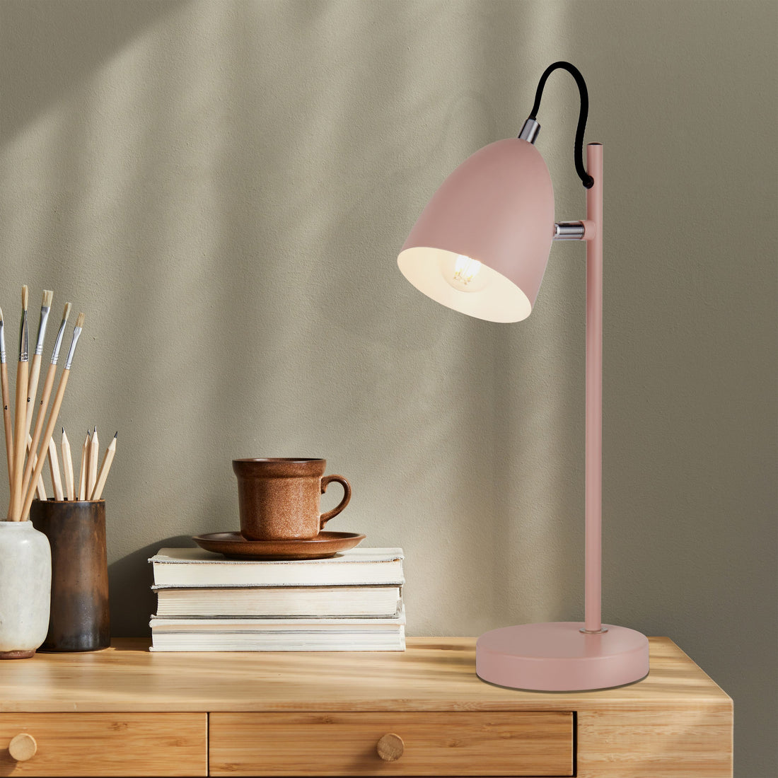Une lampe de bureau rose et orientable